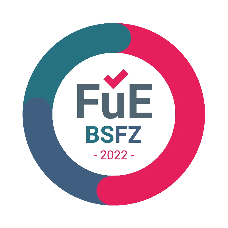 FüE BSFZ 2022 Logo mit Haken in einem Kreis aus drei farbigen Segmenten.